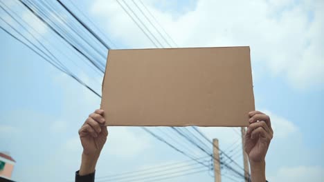 demonstrator holding empty cardboard aloft