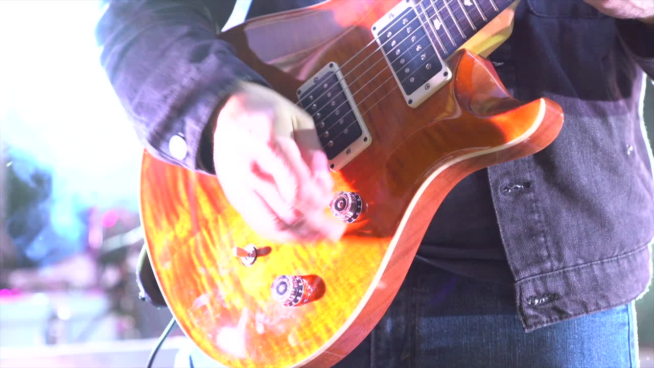 miembro de la banda rockeando en una guitarra