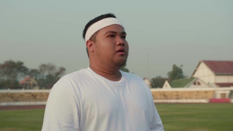 overweight man at stadium, ready to exercise