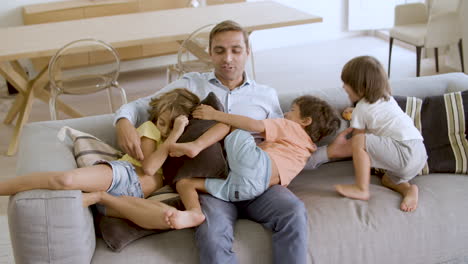 excited sibling kids running to dad on couch