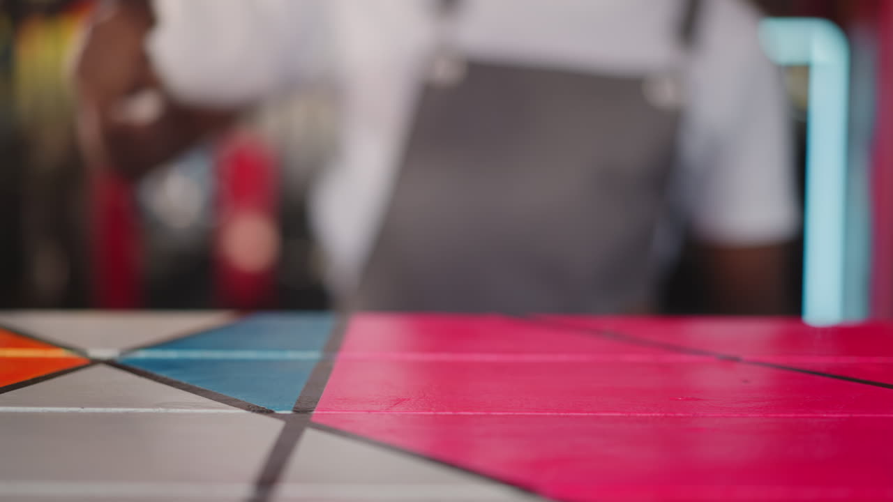 Barkeep wipes countertop in bar closeup. African American bartender does cleaning after work shift. Black barman removes dirt from table surface