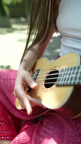 woman playing ukulele outdoors