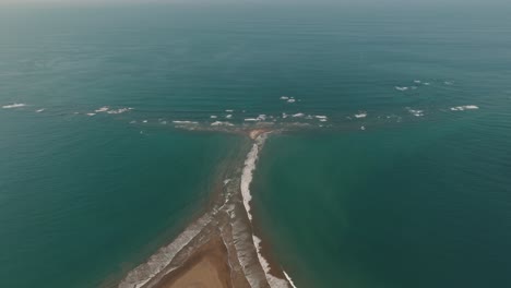 sea waves crashing on sandbar of whale's tail beach, uvita in costa rica, central america