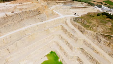 mina de piedra caliza a cielo abierto profunda con antena de agua verde cal