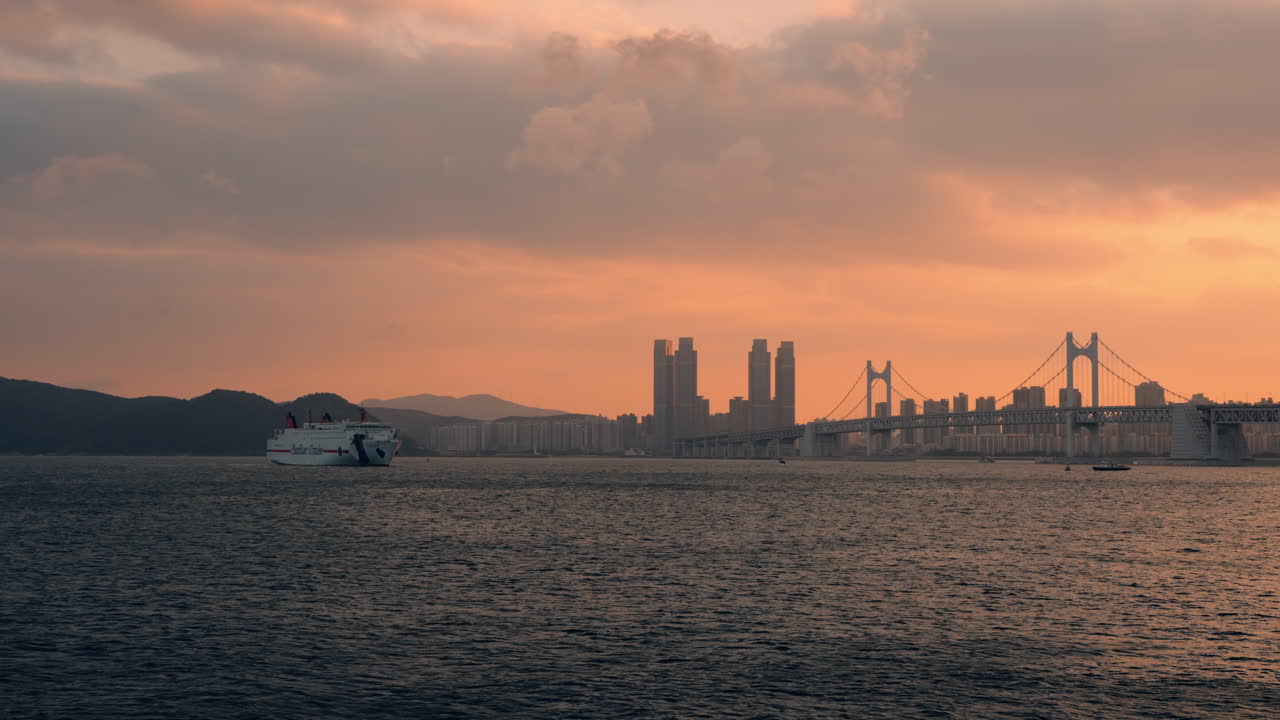 Pan Star Cruise Ship Cruising Next to Gwangan Bridge at Colorful Sunset in Busan City