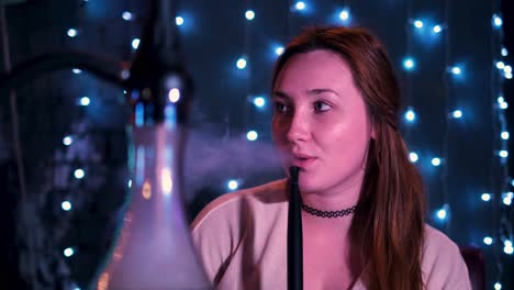 woman smoking hookah in a nightclub setting