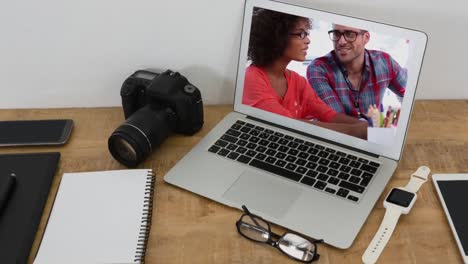 Animation-of-a-laptop-showing-a-mixed-race-couple-on-the-screen