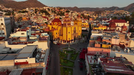 Drone-shot-rising-over-the-sunlit-Basilica-of-Guanajuato,-golden-hour-in-Mexico