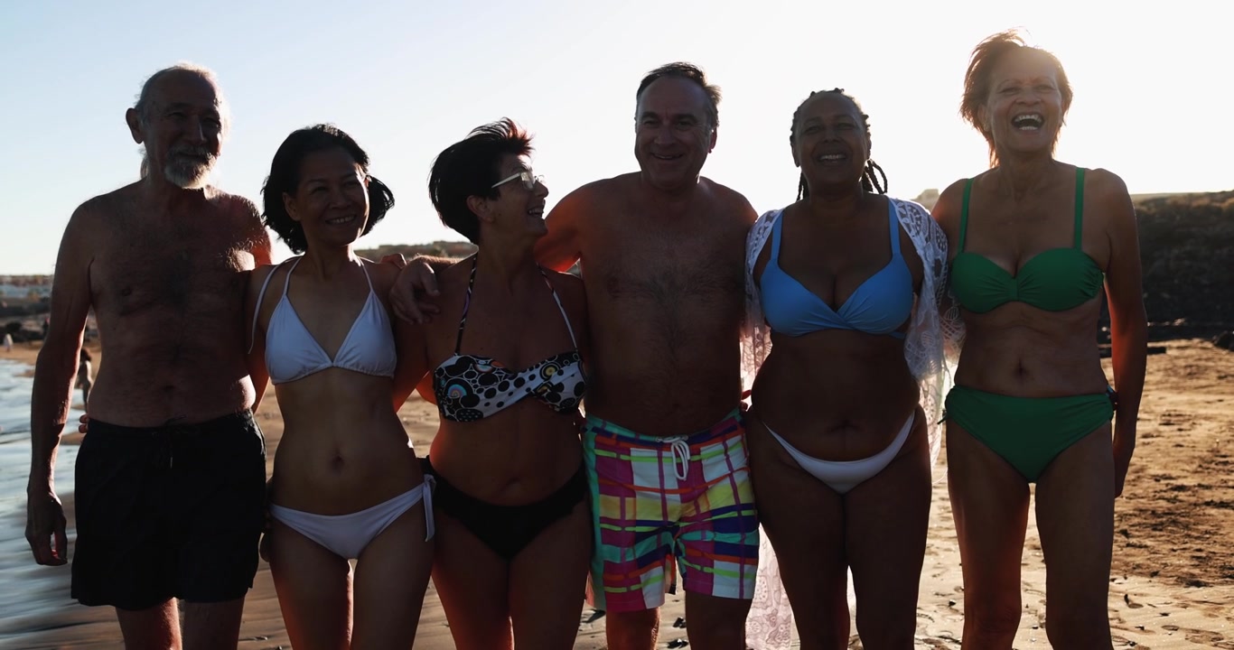 Amigos idosos diversos e felizes sorrindo e rindo na praia