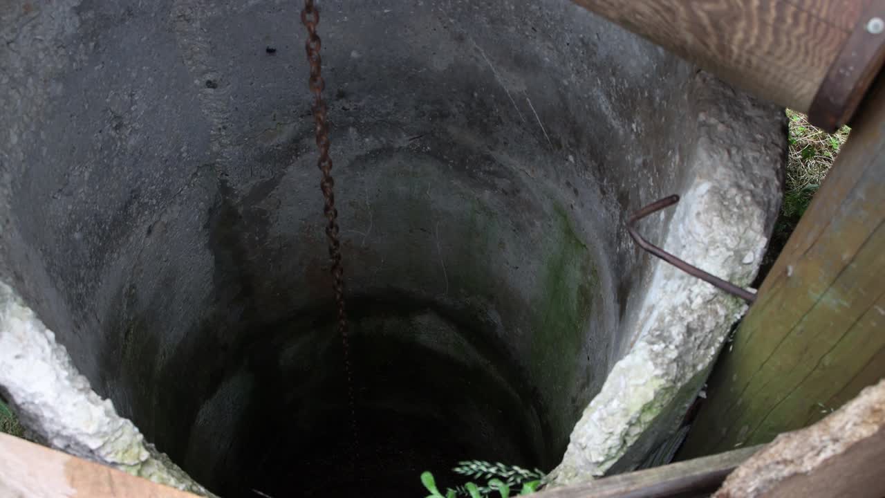 A bucket filled with water slowly rises from the well.