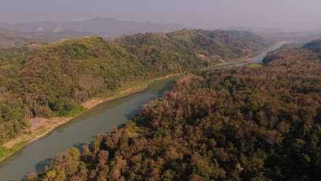 aerial view of a river winding through a lush valley and mountains