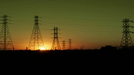 the sun sets behind high tension lines in this time lapse shot