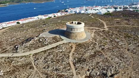 Conical-military-historical-watchtower-landmark,-harbour-coast,-aerial