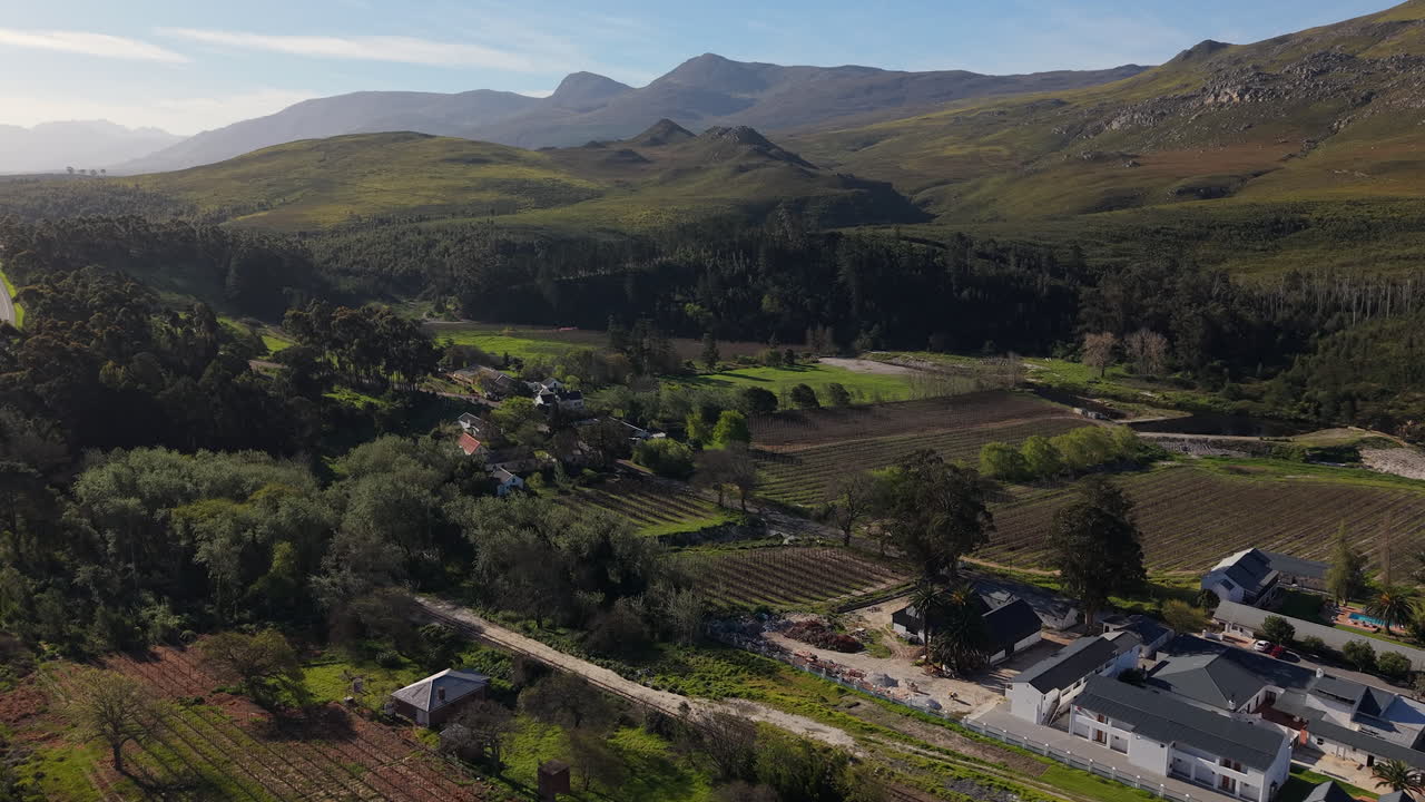 A Road Is Running Through Dense Vegetation And Cultivated Agricultural Land Near A Village. Aerial Orbiting Shot