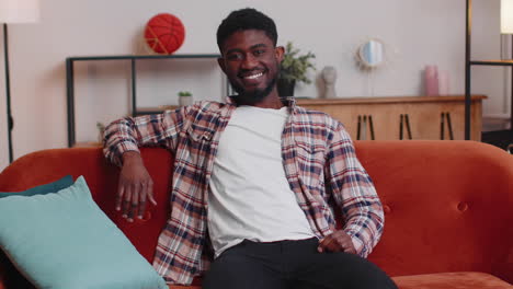 Portrait-of-happy-one-beautiful-teenager-student-guy-smiling,-looking-at-camera-at-home-on-sofa