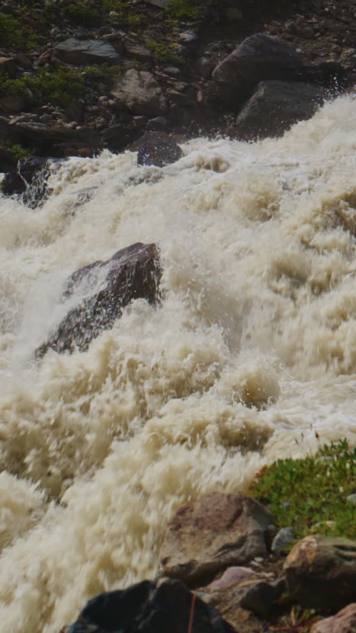 Fiume di montagna impetuoso con acqua spumeggiante che scorre sulle rocce