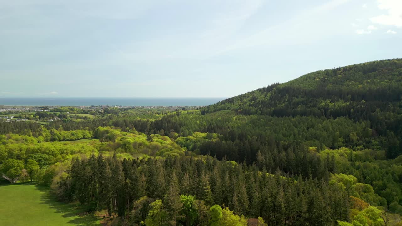 Slow, advancing aerial video of the Mourne Mountains and Slieve Donard in Newcastle, County Down in Northern Ireland, UK on a bright and sunny day. Filmed in 4K, 60fps and with Rec709 Color.