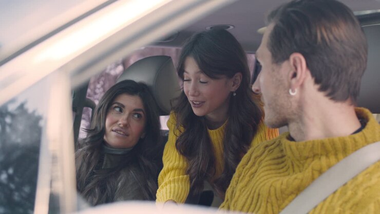 Marito e moglie seduti sui sedili anteriori di un'auto 4.