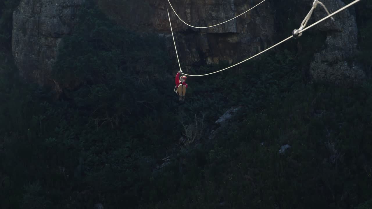 Giovane uomo caucasico che fa zip-line