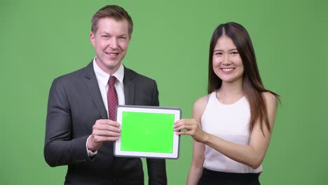 multi-ethnic business couple showing digital tablet together