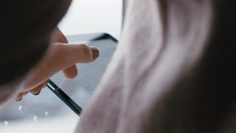 close up woman hands using digital tablet computer browsing online messages reading social media enjoying mobile touchscreen device standing by window relaxing at home on cold rainy day