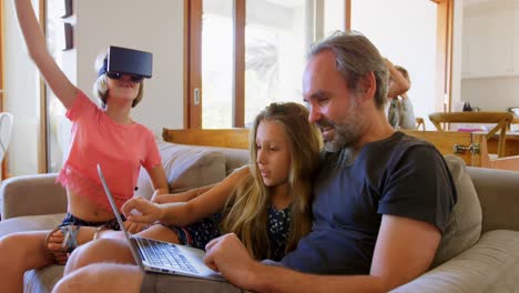father and daughter using laptop in living room 4k