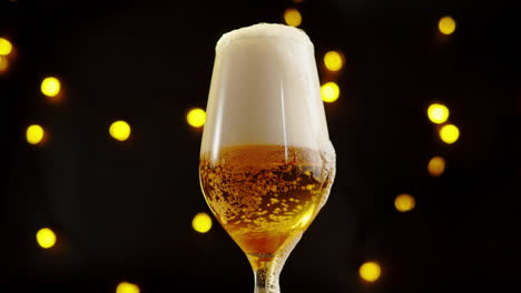 glass of frothy beer with festive lights