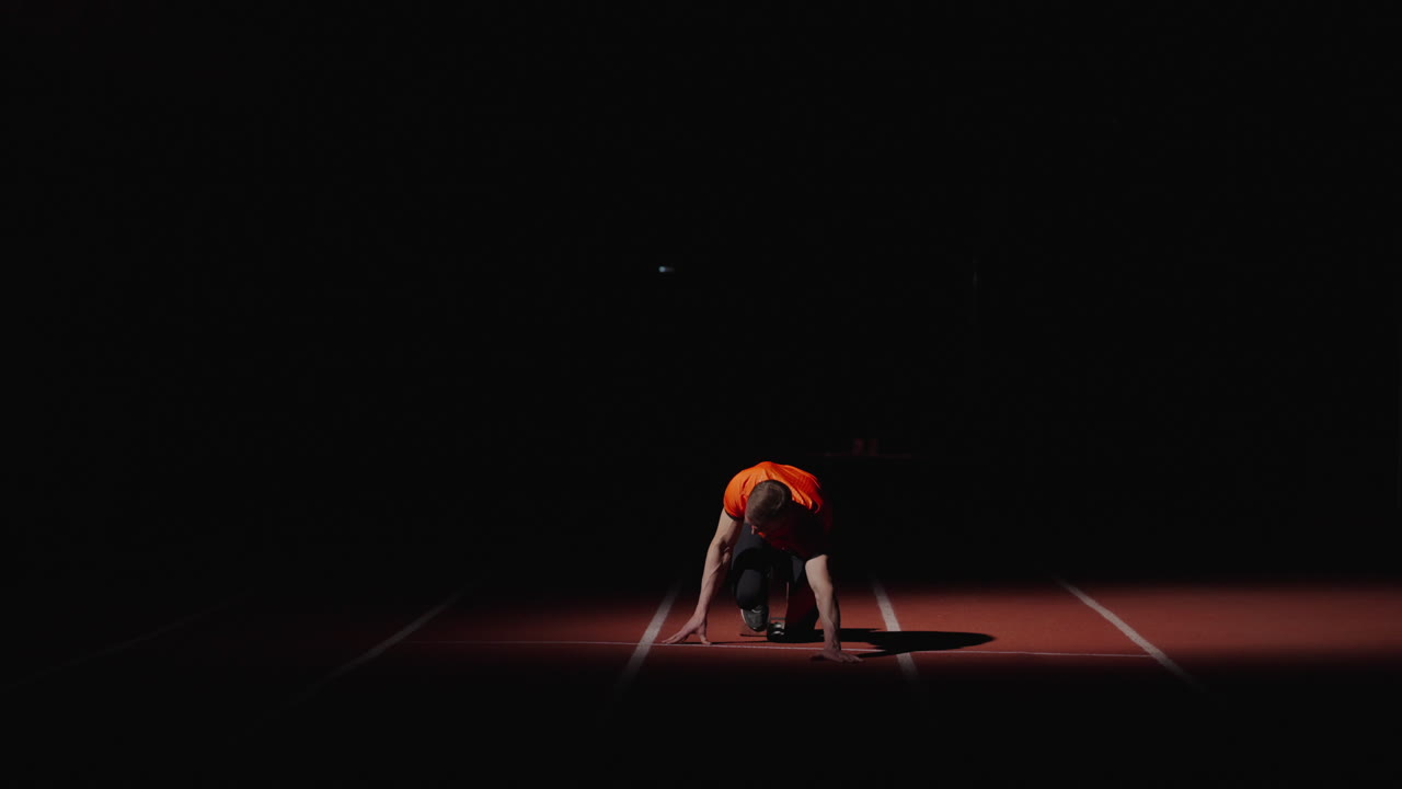 밤에 출발 위치에 있는 달리기 선수