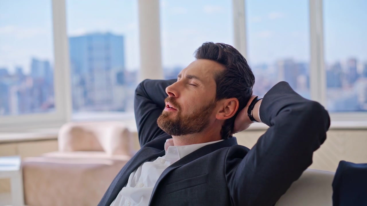 Uomo che beve acqua e si rilassa in un appartamento di lusso. Uomo d'affari che riposa con vista sulla città.