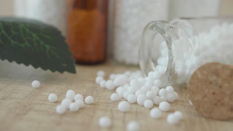 homeopathic pills in a bottle on a wooden table