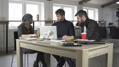 equipo de jóvenes diseñadores teniendo una reunión en la oficina creativa. discusión de negocios. filmado en 4k