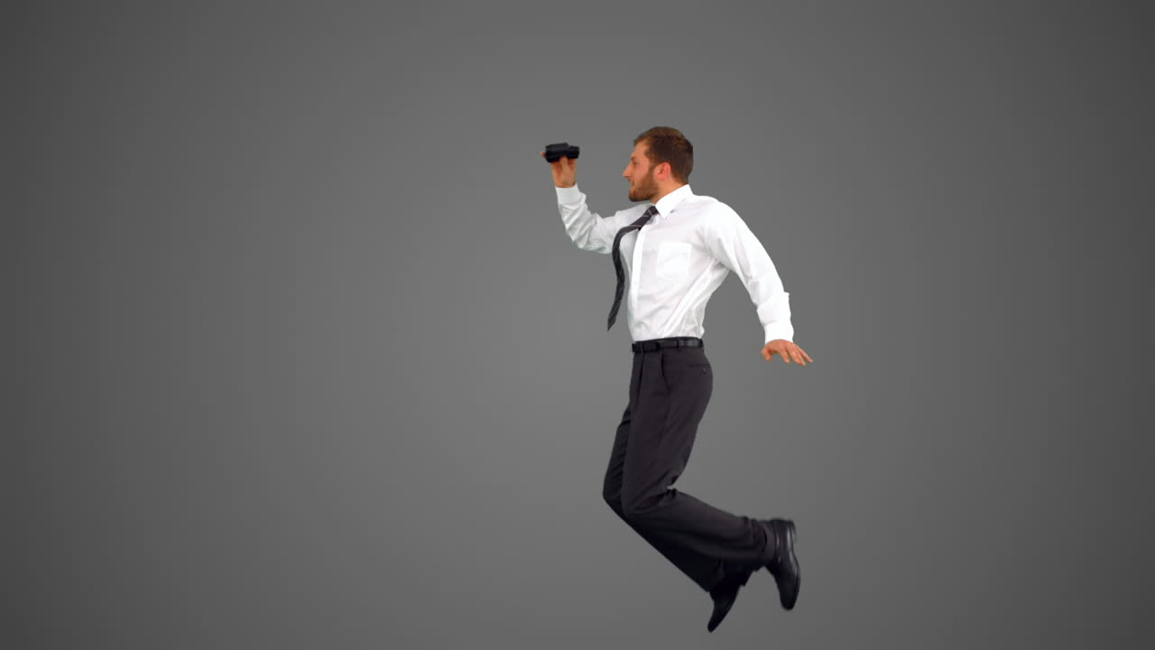 회색 배경에 안경을 들고 뛰어다니는 사업가