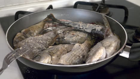 sea fish is fried in a frying pan for lunch with close up view