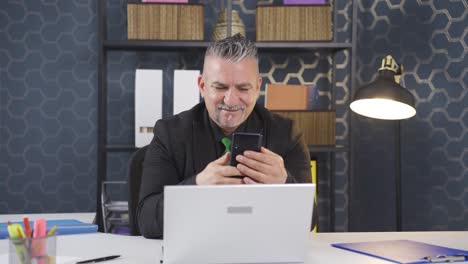 Happy-businessman-using-phone-laughing.