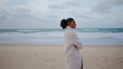 Mujer-Afroamericana-Paseando-Por-La-Orilla-Del-Océano.-Viajero-Pensativo-Mirando-Las-Olas