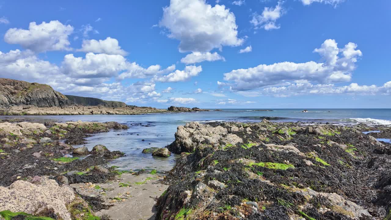 Scenic rocky beach with blue sky and white clouds