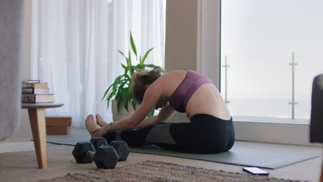 mujer caucásica sana haciendo ejercicio en casa practicando estiramientos en la sala de estar disfrutando del ejercicio físico matutino