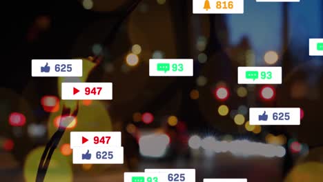 Animation-of-social-media-icons-floating-against-blurred-view-of-night-city-traffic