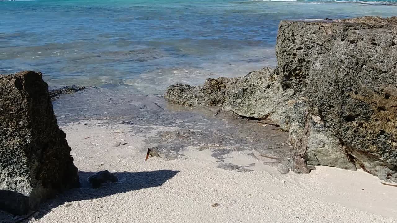 agua de mar de bahamas rompiendo suavemente sobre las rocas. de cerca