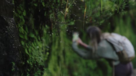 Travel-Blonde-Girl-Taking-Photos-of-Raindrops-Falling-From-Leaves