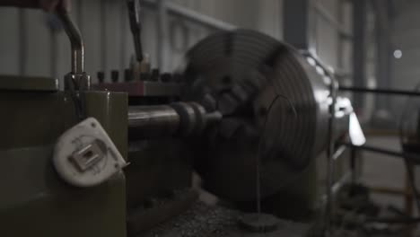 detail-close-up-of-CNC-lathe-machine-at-work,-Indian-black-workers-controlling-the-production-process-in-old-fashioned-factory