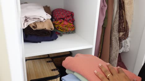 woman folding clothes in closet