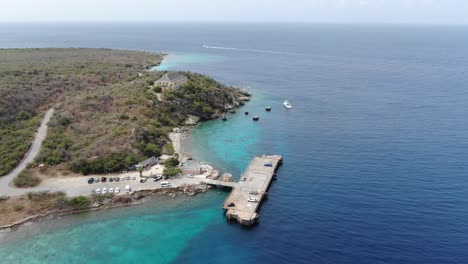 Tugboat-beach-in-curacao-with-clear-waters-and-moored-boats,-aerial-view