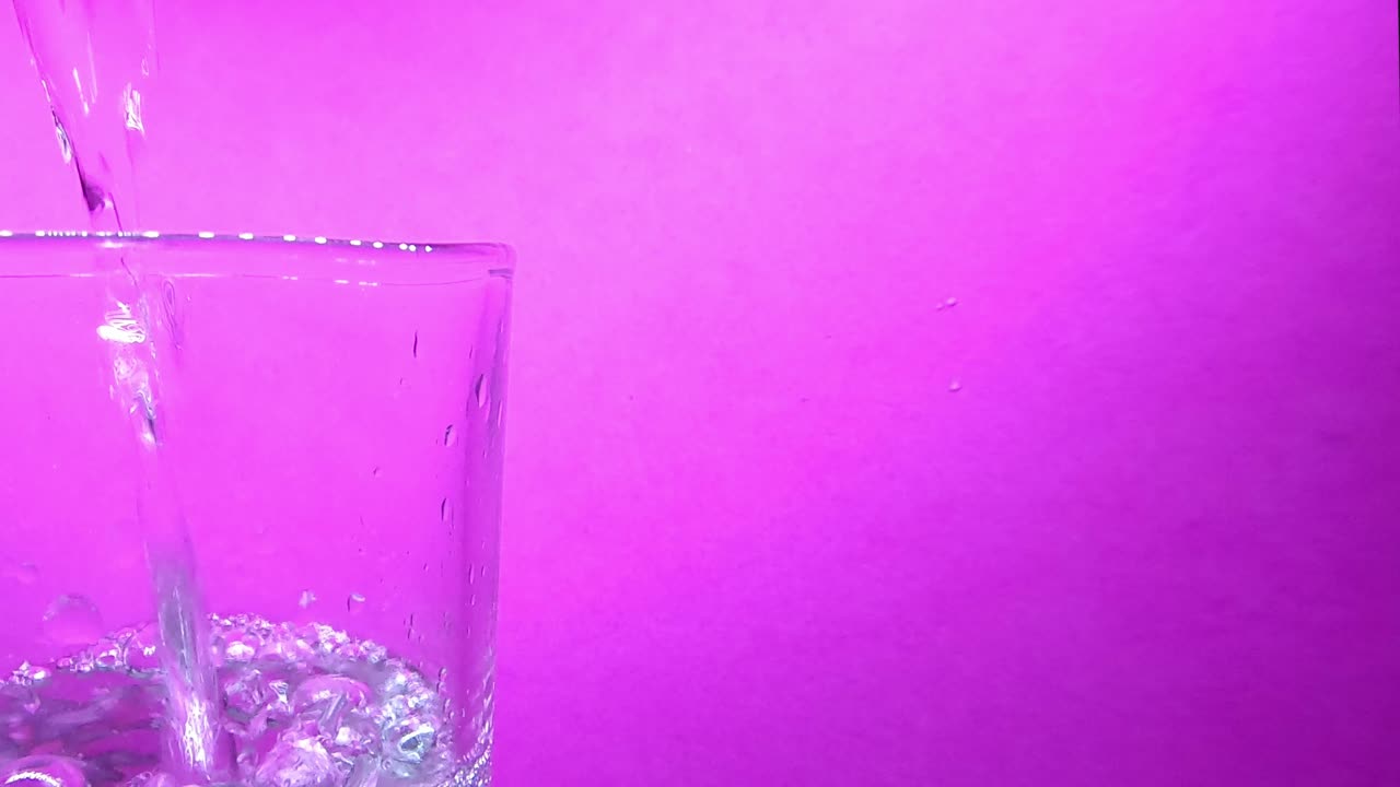 Agua vertiéndose en un vaso que está a la izquierda del video.