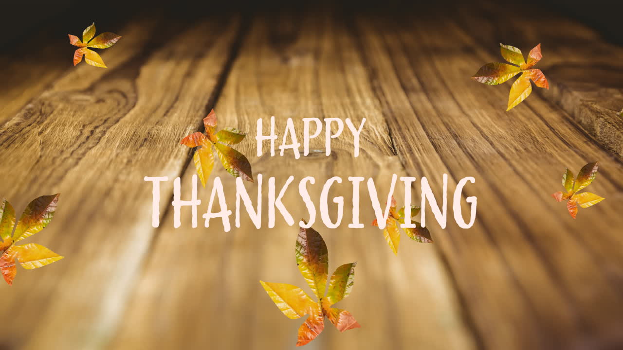 Animation of happy thanksgiving text over autumn leaves on wooden boards
