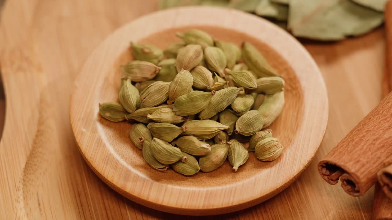 Cardamom and spices on a wooden plate