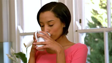 mujer bebiendo por una taza blanca bonita