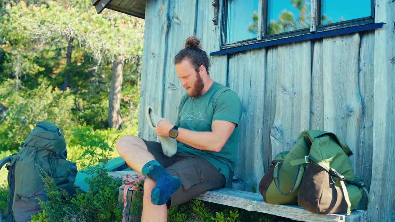 한 남자가 그의 양말과 신발을 입고, imalitjønna, indre fosen, trøndelag, 노르웨이에서 하이킹을 준비하고 있었다 - 정적