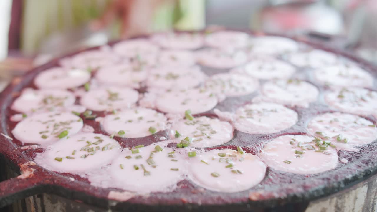 cocina de primer plano comida tradicional tailandesa de calle postre dulce khanom krok, panqueque de leche de coco mezcla azúcar y harina en proceso con cebollas de primavera en la parte superior