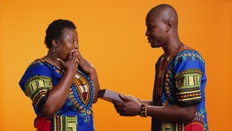 Romantic-man-offering-present-with-ribbon-and-bow-to-his-wife